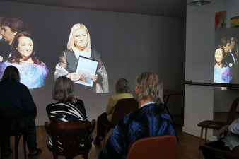 Mieszkańcy oglądają transmisję na żywo Gali osób niepełnosprawnych prowadzoną przez Anne Dymną